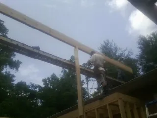 Carpenter setting a ridge beam over a new addition frame — Ice Dam Removal by Roofing Brothers in Las Cruces